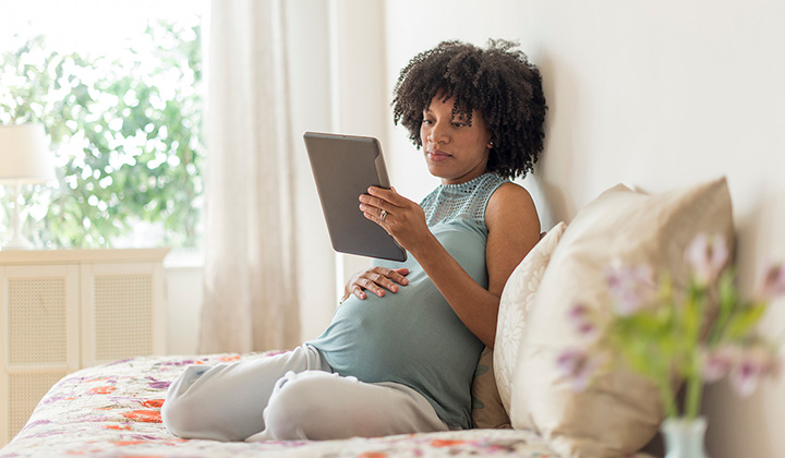 Pregnant woman looking at tablet