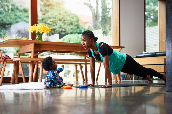 Woman doing yoga with child next to her