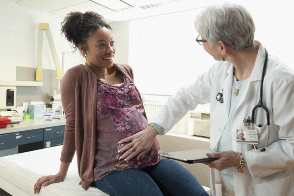 Pregnant woman and physician performing check up