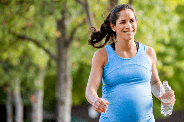 Pregnant woman exercising with water bottle